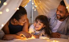 father-and-mother-with-daughter-in-tent-with-lights.jpg