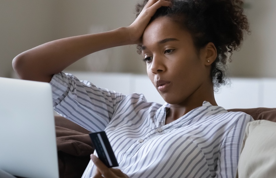 Teenage girl puts hand up to her head and looks upset at something she sees on her phone