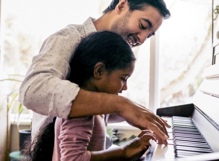 Dad teaches child to play piano