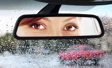 womans eyes seen in car rear view mirror